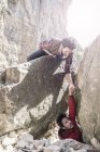 Montanhistas ajudando uns aos outros durante a escalada difícil — Fotografia de Stock