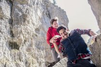 Альпинисты помогают друг другу во время трудного восхождения — стоковое фото