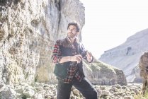 Bergsteiger steht mit Wasserflasche — Stockfoto