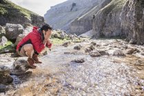 Alpiniste s'arrêtant pour se laver dans le ruisseau de montagne — Photo de stock