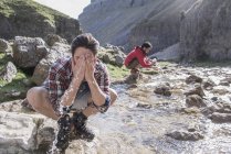 Bergsteiger waschen sich in Bach — Stockfoto