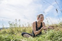 Femme dans prairie pratiquant le yoga — Photo de stock