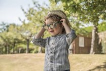 Хлопчик одягає сонцезахисні окуляри — стокове фото