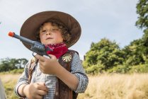 Junge spielt Cowboys und Indianer draußen — Stockfoto