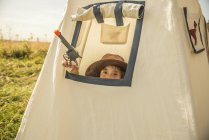 Boy plays cowboys and indians outside — Stock Photo