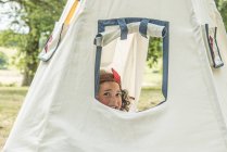Young girl sitting in wigwam — Stock Photo