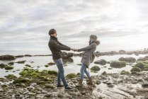 Coppia che si tiene per mano sulla spiaggia — Foto stock