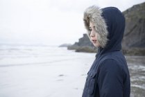 Хлопчик стоїть на пляжі — стокове фото