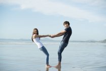 Пара тримає руки на пляжі — стокове фото