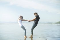 Casal de mãos dadas na praia — Fotografia de Stock