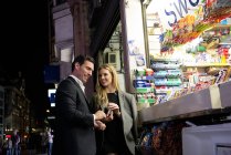 Couple buying confectionery from kiosk — Stock Photo