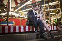 Couple cuddling by carousel — Stock Photo