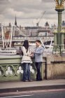 Пара говорить, стоячи на мосту — стокове фото