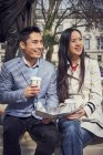 Paar sitzt auf Brüstung und trinkt Kaffee — Stockfoto