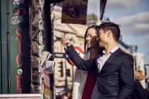 Paar wählt Postkarten im Ständer — Stockfoto