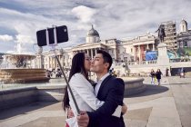 Пара делает селфи у фонтана на Трафальгарской площади — стоковое фото