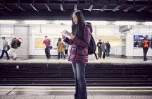 Mujer japonesa de pie en la estación de metro - foto de stock