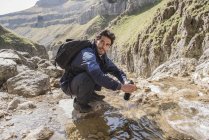 Альпинист наполняет бутылку с водой — стоковое фото