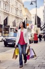 Mulher andando com sacos de compras — Fotografia de Stock
