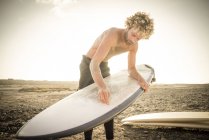 Hombre preparando tabla de surf - foto de stock