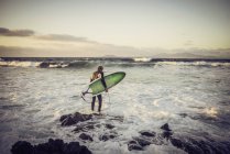 Mann im Neoprenanzug bereitet sich auf das Surfen vor — Stockfoto