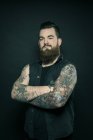 Uomo con braccia tatuate incrociate — Foto stock