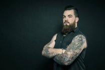 Людина зі складеними татуйованими руками — стокове фото