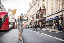 Mujer llamando a un taxi en Regent Street - foto de stock