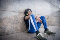 Homem ouvindo música via fones de ouvido — Fotografia de Stock