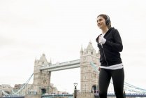 Woman jogging past Tower Bridge — Stock Photo