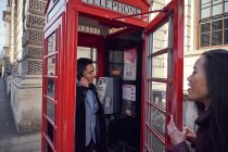 Man making phone call in telephone box — Stock Photo