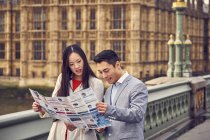 Couple pondering over city guide — Stock Photo