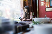 Woman sitting at table and looking at window — Stock Photo