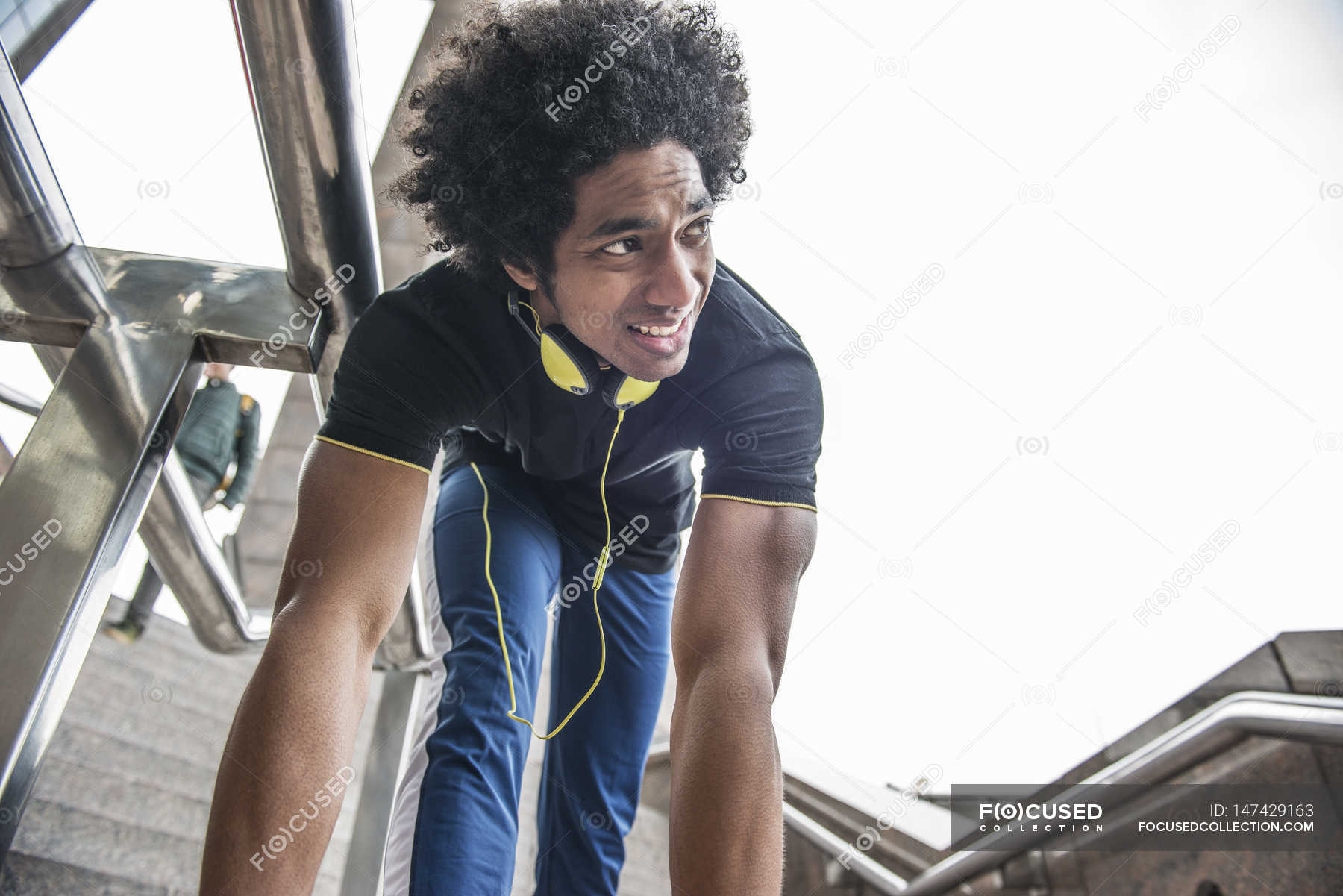 Man limbering up leg for jog — ethnic, music - Stock Photo | #147429163