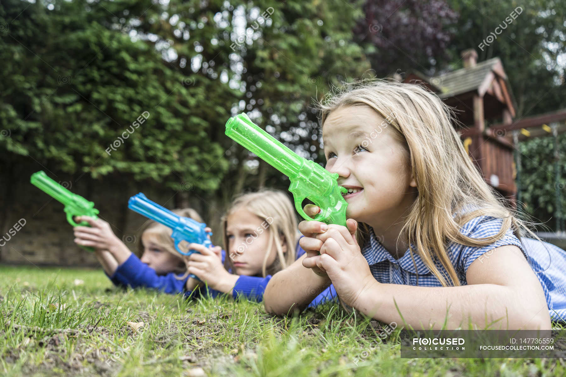 Girls playing with water pistols — school uniforms, fun - Stock Photo ...