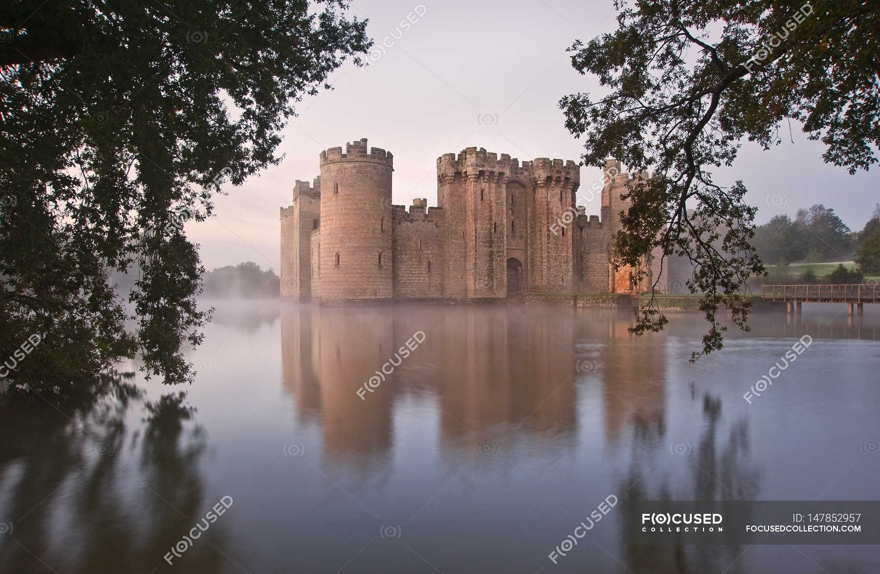 Beautiful medieval castle and moat at sunrise — stone, tower - Stock