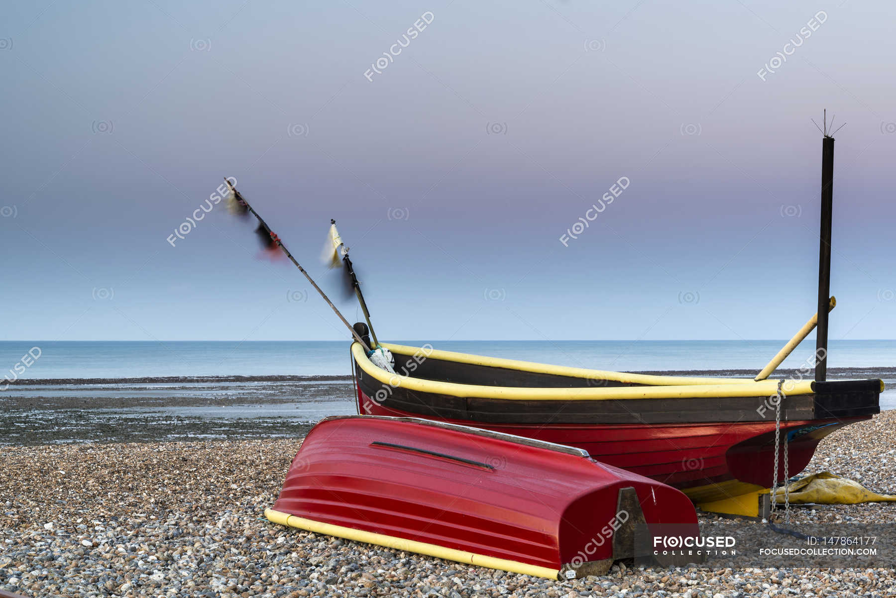 small-fishing-boats-on-beach-at-sunrise-coast-colour-stock-photo