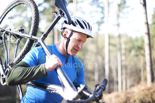 Людина несе гірський велосипед — стокове фото