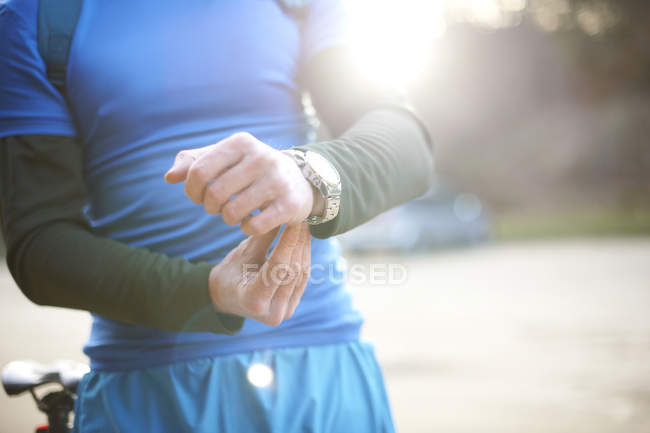 Hombre sujeta reloj antes del ejercicio - foto de stock
