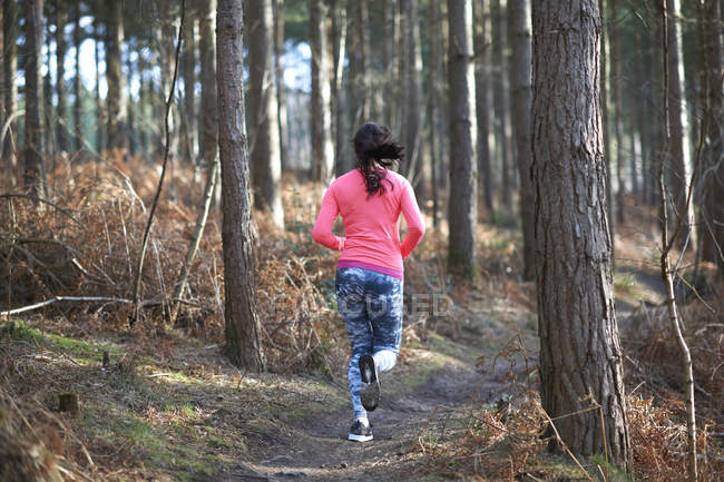 Woman running in woods — Stock Photo