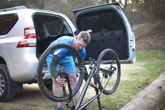 Людина фіксує гірський велосипед — стокове фото
