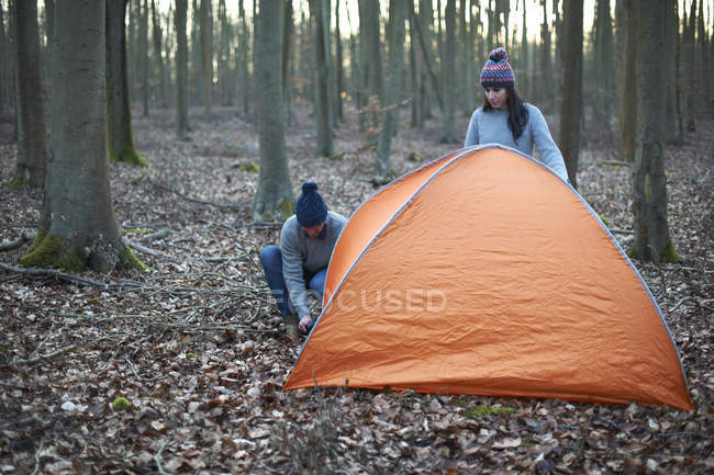 Casal colocar a barraca na floresta — Fotografia de Stock