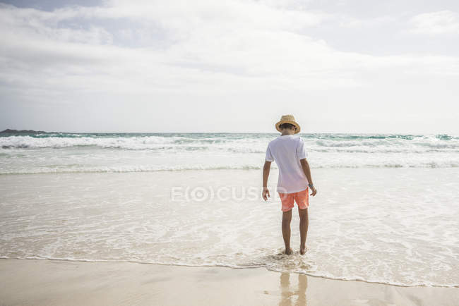 Garçon marche sur la plage — Photo de stock