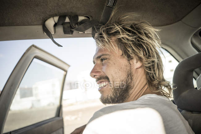 Surfista masculino sentado en el coche - foto de stock