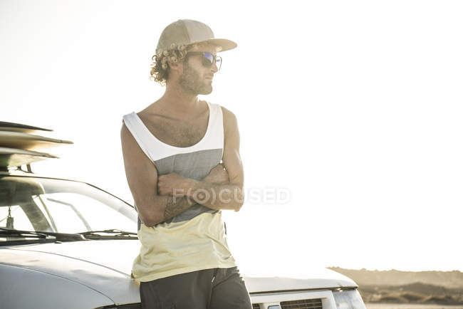 Серфер, стоящий на машине — стоковое фото
