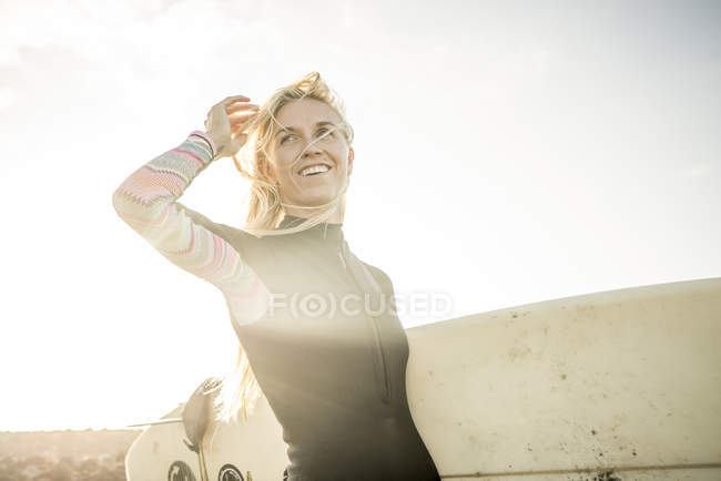 Женщина в гидрокостюме готовится к серфингу — стоковое фото