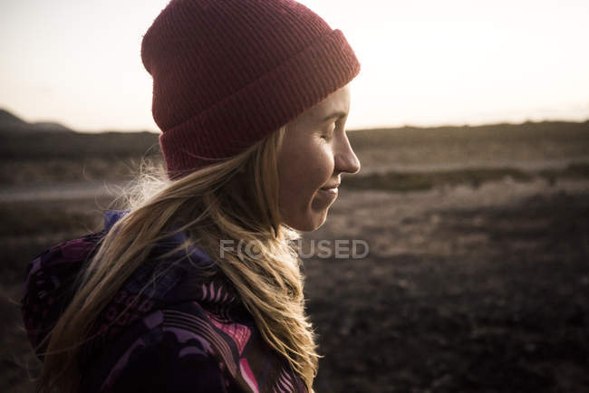 Mulher com chapéu vermelho em pé na praia — Fotografia de Stock
