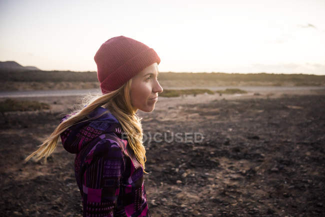 Woman with red hat standing on beach — Stock Photo
