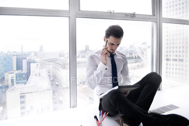 Businessman making notes on pad — Stock Photo