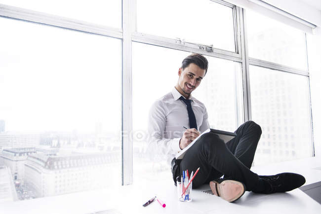 Empresário fazendo anotações no pad — Fotografia de Stock